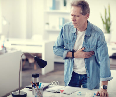 Man Standing at His Desk Holding His Chest Is Heart Disease Curable